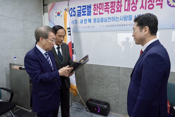 [상패를 전달 받는 서인택 통일천사 공동상임의장의 모습]